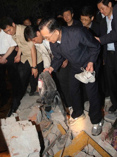 温家宝冒雨攀上瓦砾堆摔倒手臂出血